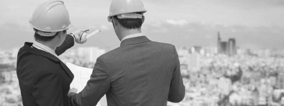 a man and woman wearing hardhats looking at a city construction management leader