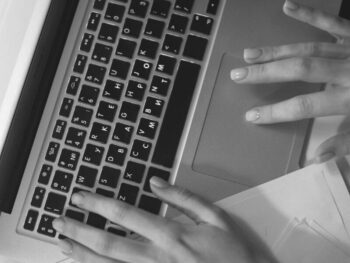 Hands typing on a laptop keyboard