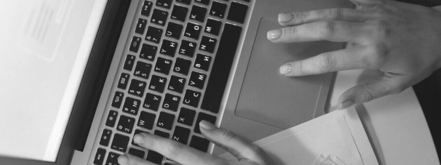 Hands typing on a laptop keyboard
